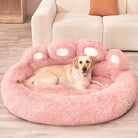 Chien allongé sur un lit pour animaux en forme de patte, rose et moelleux, dans un salon moderne. Lit pour chien confortable, design original.